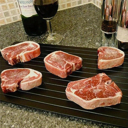 Ploca za brzo odmrzavanje mesa sa steak komadima na kuhinjskoj radnoj povrsini
