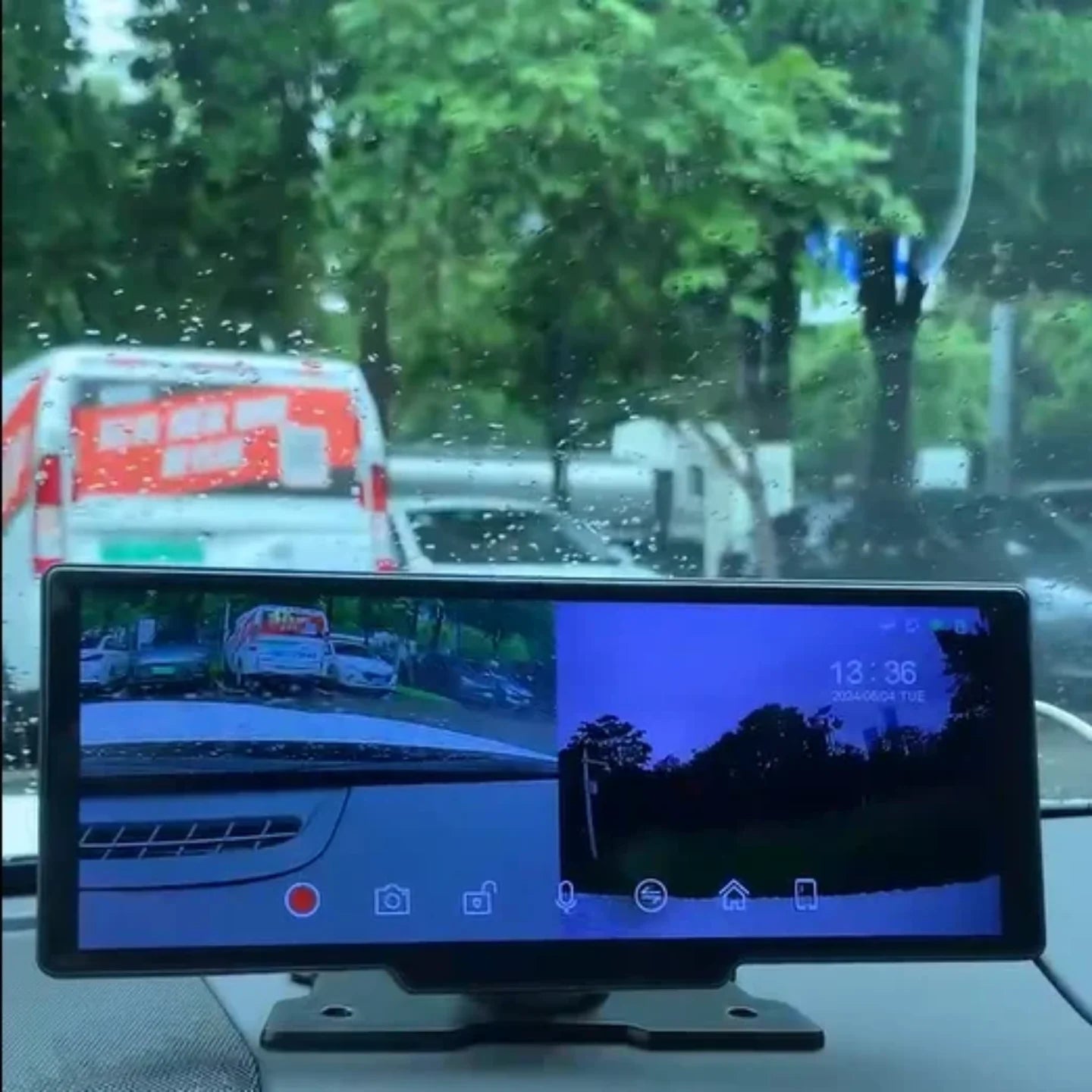 Podeljeni prikaz snimka sa prednje i zadnje auto kamere na prenosnom ekranu tokom voznje po kisi