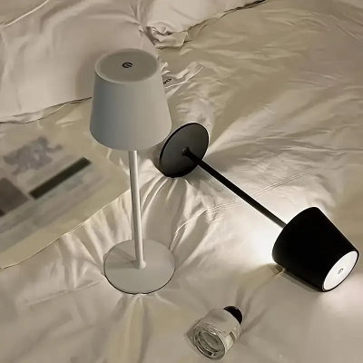 Dve prenosive led lampe crna i bela na krevetu moderna rasveta za spavacu sobu minimalisticki dizajn idealno za citanje