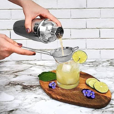 Ruke sipaju pice iz shakera. Proces pravljenja koktela, prikaz upotrebe barmen seta za savrsen ukus u kucnoj varijanti.