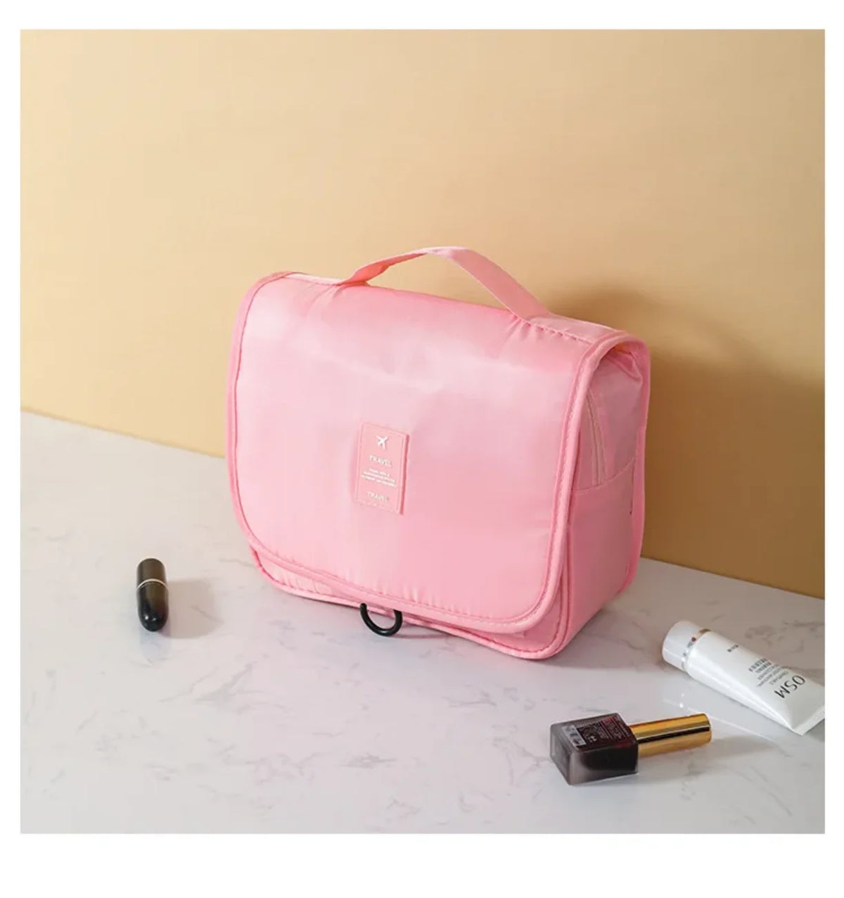 Roze putni neseser za sminku zatvoren na stolu