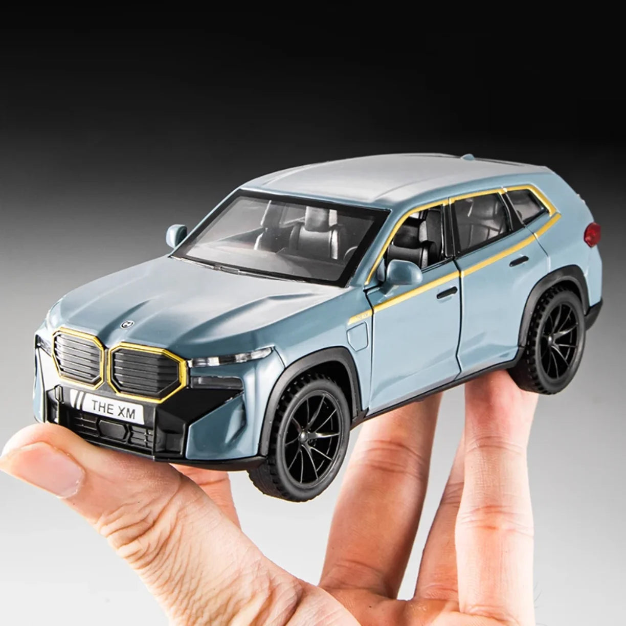 Plavi metalni RC auto BMW XM 1:24 na prstima ruke
