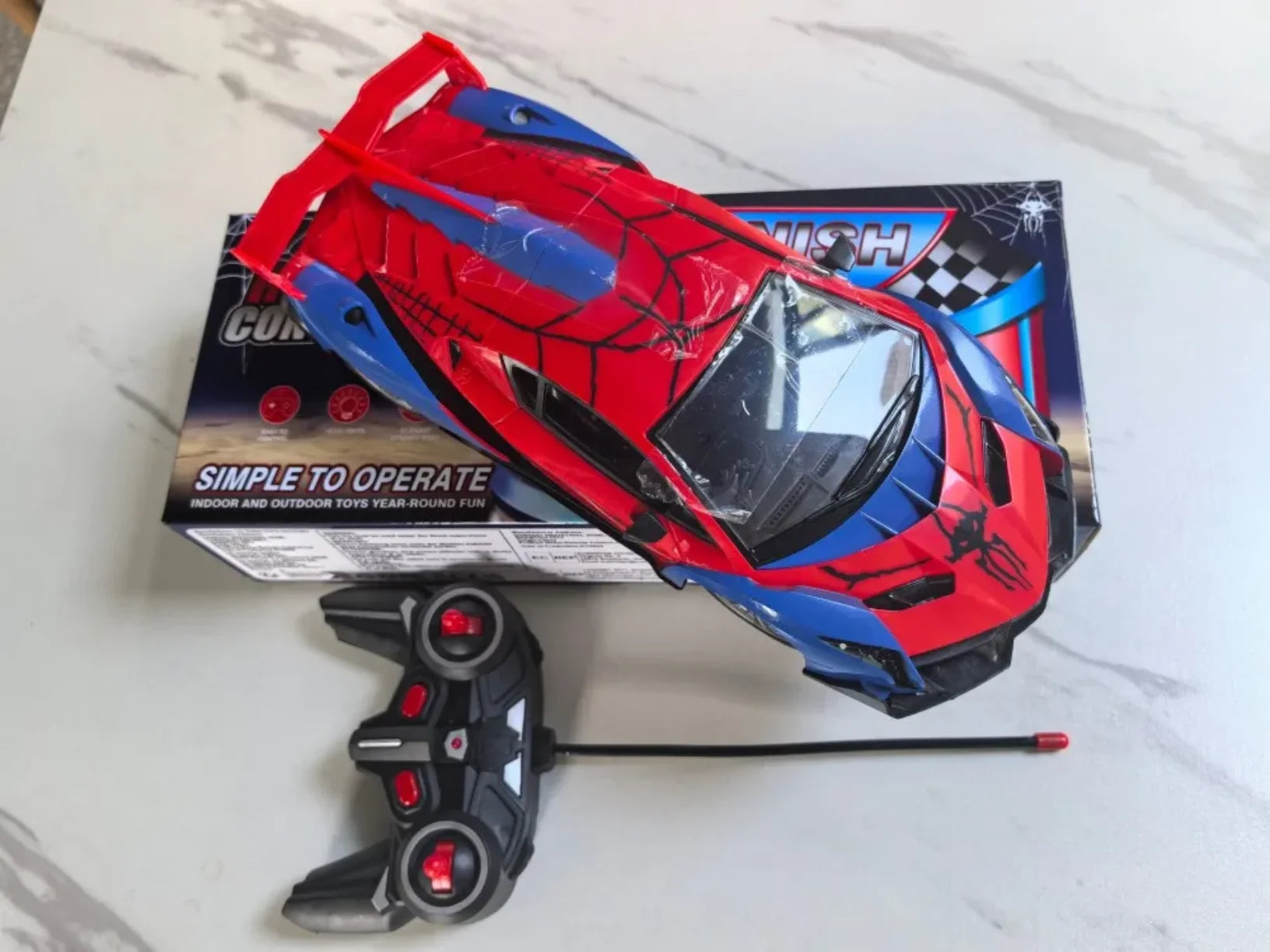 RC sportski auto crveno plavi sa daljinskim na stolu