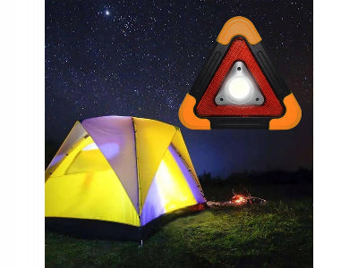 Lampa reflektor u obliku trougla koja osvetljava sator tokom noci, idealna za kampovanje i boravak u prirodi.