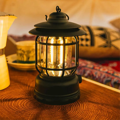 Retro kamperska lampa sa toplim zutim svetlom na stolu