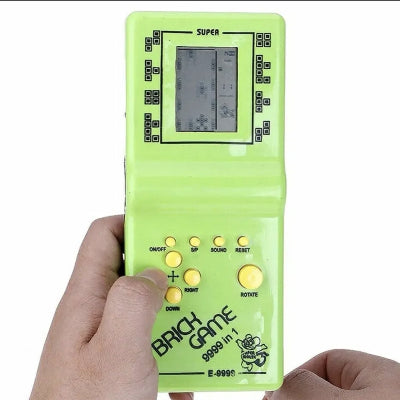 U rucu prikazana zelena Tetris konzola. Retro prenosiva igrica za decu, savrsena za kratkotrajnu zabavu i odmor.