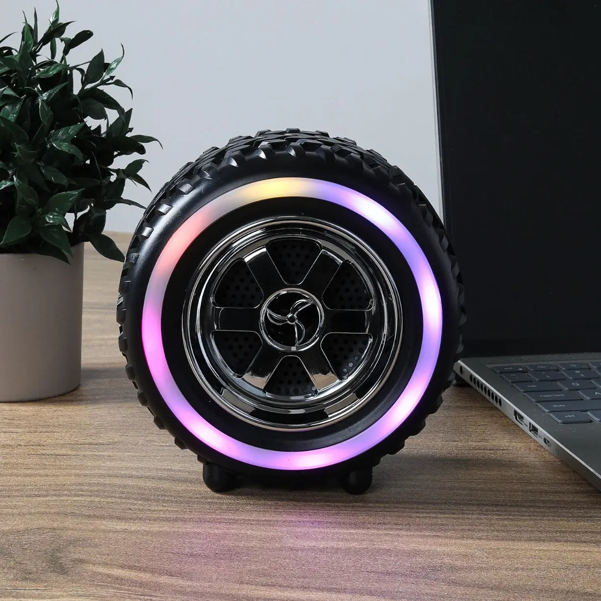RGB bluetooth zvucnik u obliku gume na stolu pored laptopa