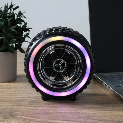 RGB bluetooth zvucnik u obliku gume na stolu pored laptopa