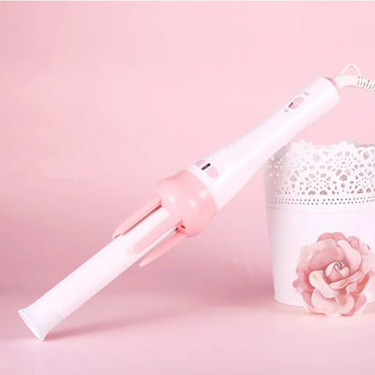 Rotirajuci uvijac za kosu na roze pozadini sa dekoracijom
