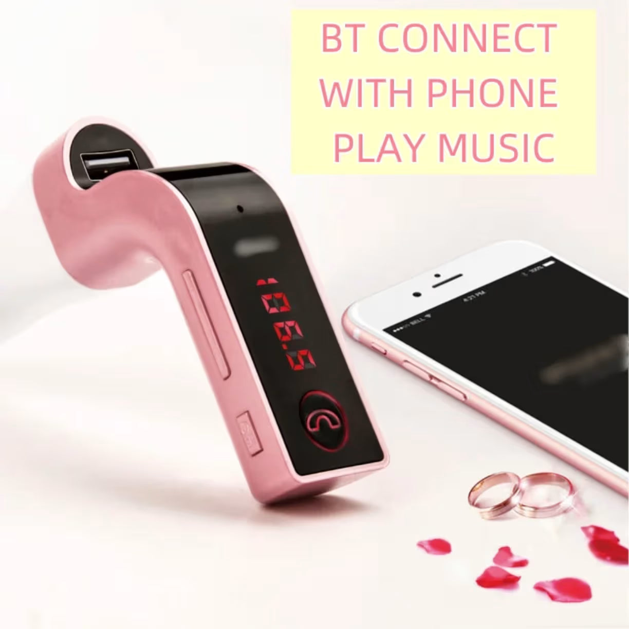 Roze Bluetooth FM transmiter položen pored pametnog telefona za bežično puštanje muzike