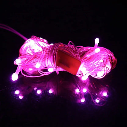 Roze novogodisnje LED lampice ukljucene u mraku