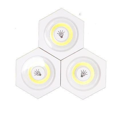 Tri modularne bele lampe sa zutim krugom i oznakom sijalice u sredini spojene u formu pcelinjeg saca na beloj pozadini