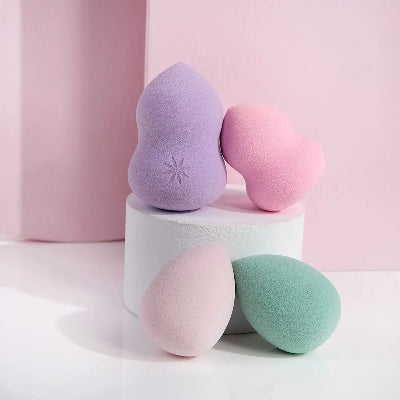 Set sminkerskih sundjera za nanosenje sminke razlicitih oblika, u pastelnim bojama. Prikazani su lila, roze, pastelno roze i menta zeleni sundjeri.