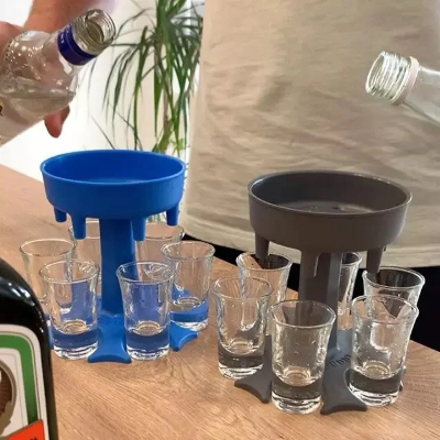 sivi i plavi shot dozeri na stolu, dva muskarca sipaju vodku i jeger u casice za zajednicko uzivanje i zabavu