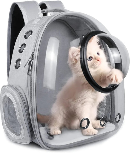 Prikaz sivog ranca za macke sa providnim prednjim delom u obliku svemirske kapsule. Unutar ranca sedi bela macka sa plavim ocima i jednom sapom ispruzenom ka prozoru. Ranac ima crne rucke i kaiseve, srebrne rajsfersluse i crne ventilacione otvore sa strane. Sa jedne strane ranca nalazi se mrezasti dzep.