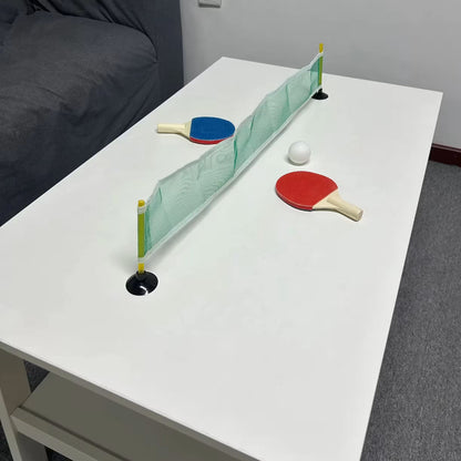 Pogled iz ugla na montiran mini ping pong set sa mrezicom i reketima spremnim za igru