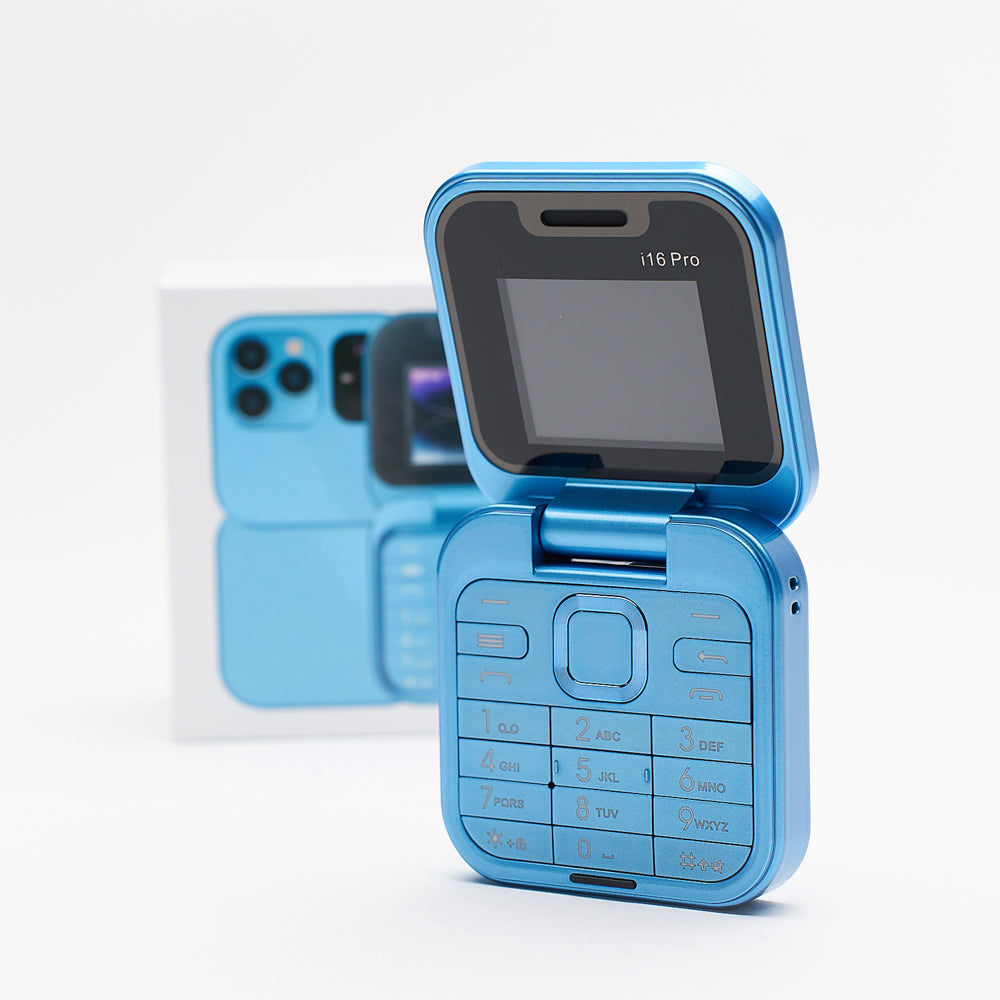 Svetloplavi mini preklopni telefon i16 Pro delimicno otvoren, prikazuje tastaturu i gornji ekran, sa zamucenim pakovanjem telefona u pozadini.