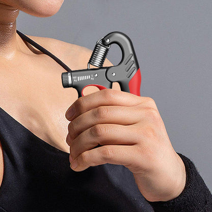 Zena koristi rucnu hvataljku za jacanje stiska. Fitnes rekvizit za vezbanje misica sake i podlaktice kod kuce. Podesiv otpor.