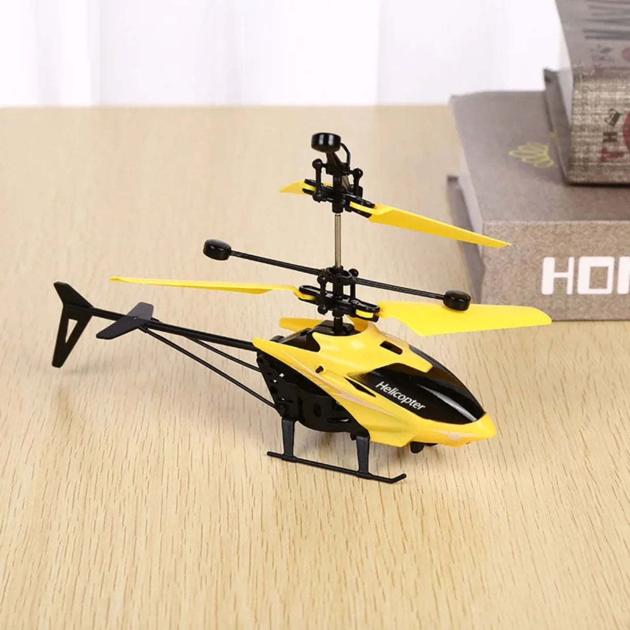 Zuti helikopter igracka sa duplim elisama na stolu